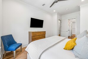 A bedroom with a bed, a chair, a dresser, a television, and a ceiling fan. - WaterColor Escape with Pool and Screened-in Porch (Santa Rosa Beach)