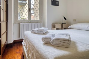 A hotel room with a bed, a window, a radiator, a nightstand, and a lamp. - Garibaldi 44 - Milan Most Vibrant District (Milano)