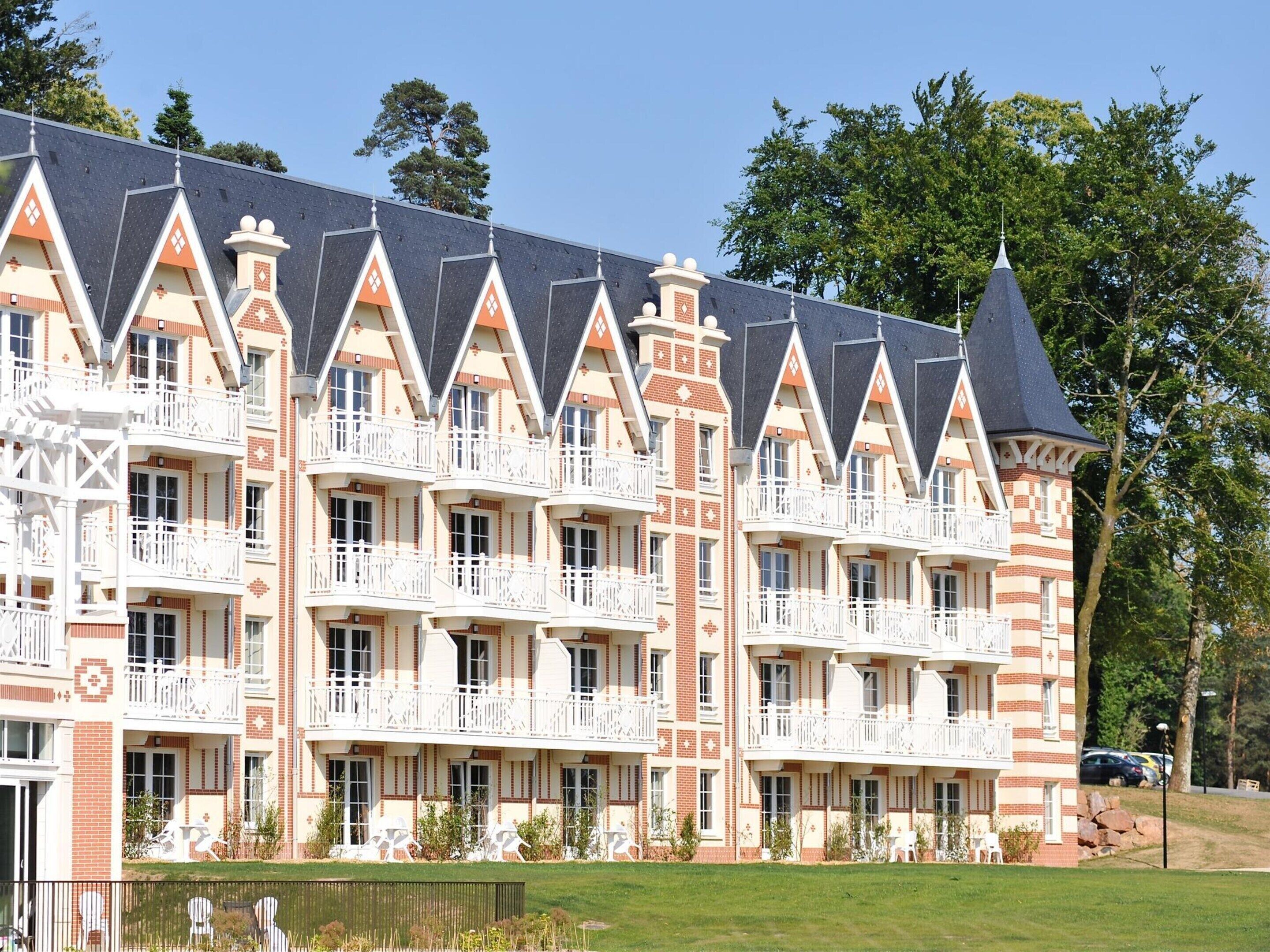 Een hotel met meerdere verdiepingen en een opvallende architectuur, met een centraal torentje en diverse balkons.