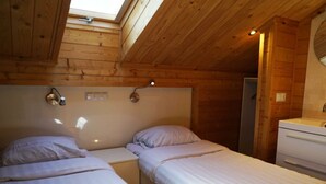 A room with two beds, a skylight, a small sink, and wooden walls. - Boekhorst L"etage 10 (Lochem)