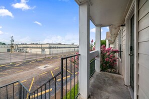 Ein Gebäude mit einer überdachten Veranda, einem Parkplatz und blauem Himmel.
