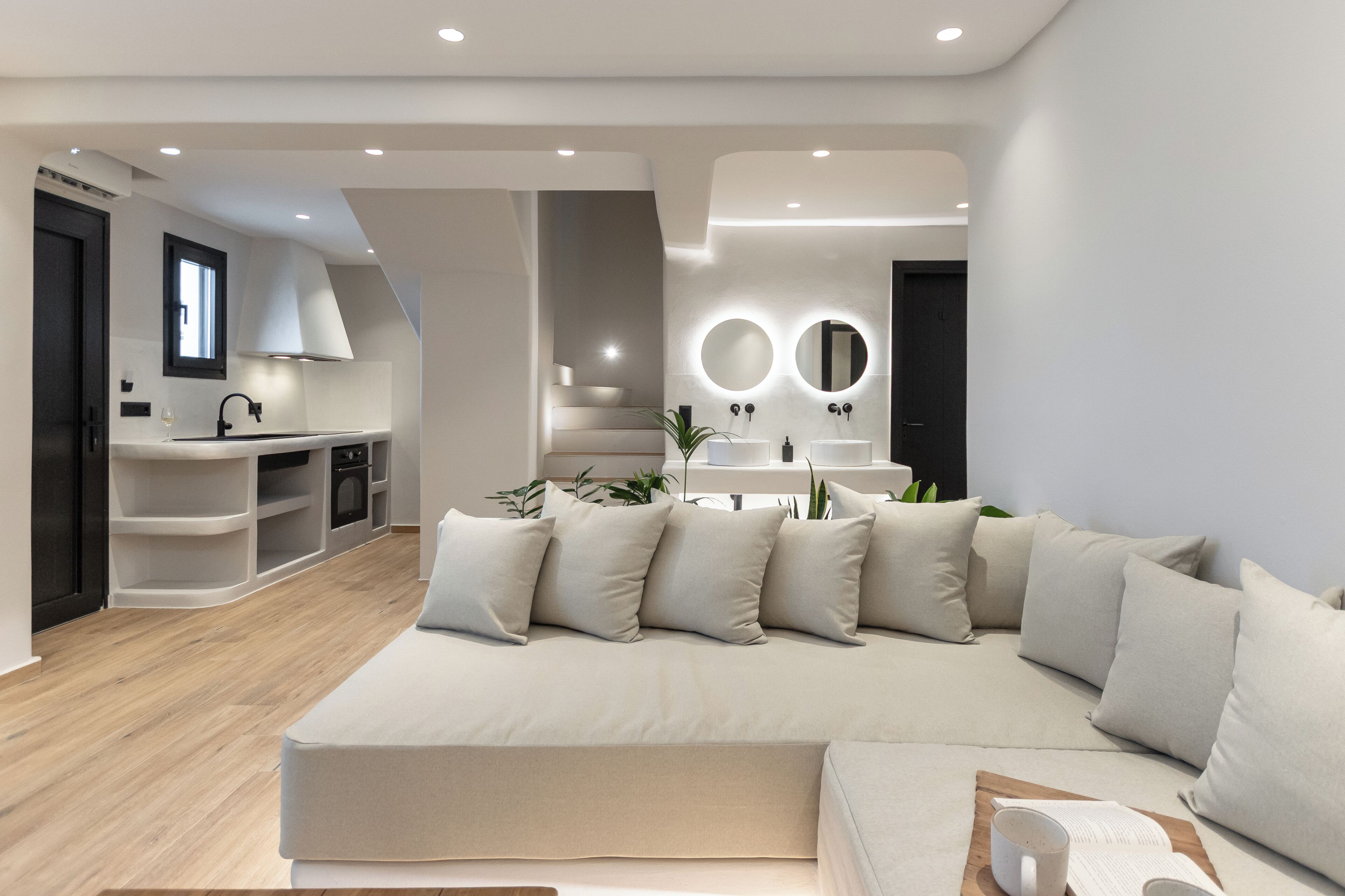A modern living room with a large sofa, a coffee table, and a bookshelf.