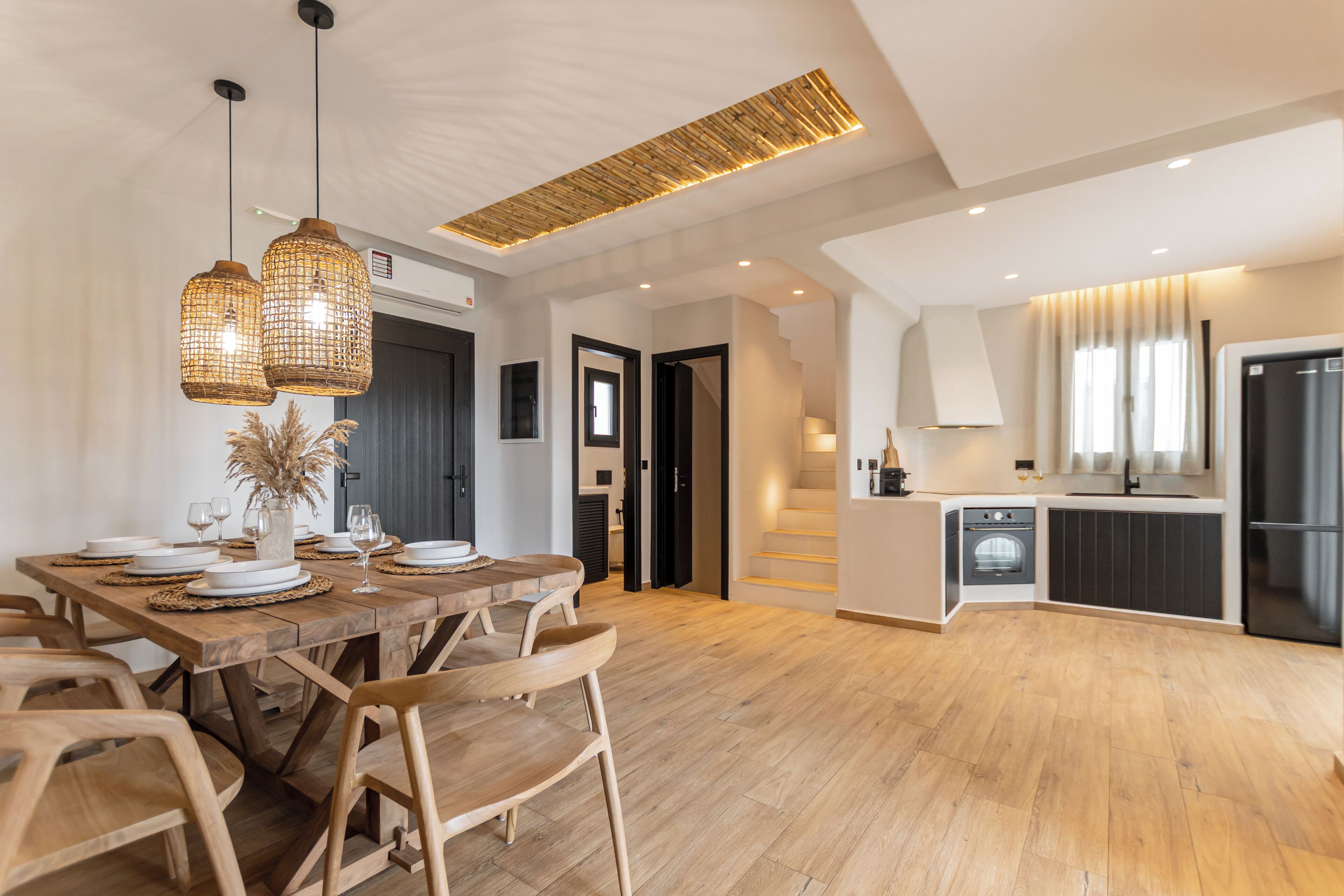 A modern kitchen with a built-in oven and a black refrigerator.