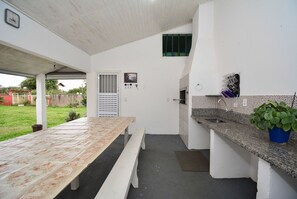 A kitchen with a granite countertop, a sink, and a potted plant. - Casa Aconchegante na Lagoa da Cigana (Laguna)