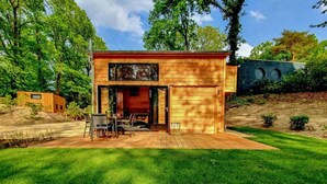 Eine moderne Holzdiele mit Terrasse, Essbereich und Garage.
