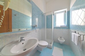 A bathroom with a sink, toilet, bidet, and a shower area. - Breeze (Barano D'ischia)