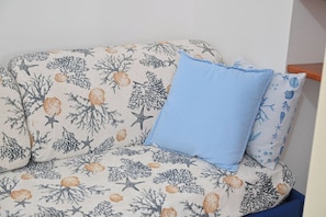 A sofa with a marine-themed fabric and a single blue cushion. - Breeze (Barano D'ischia)