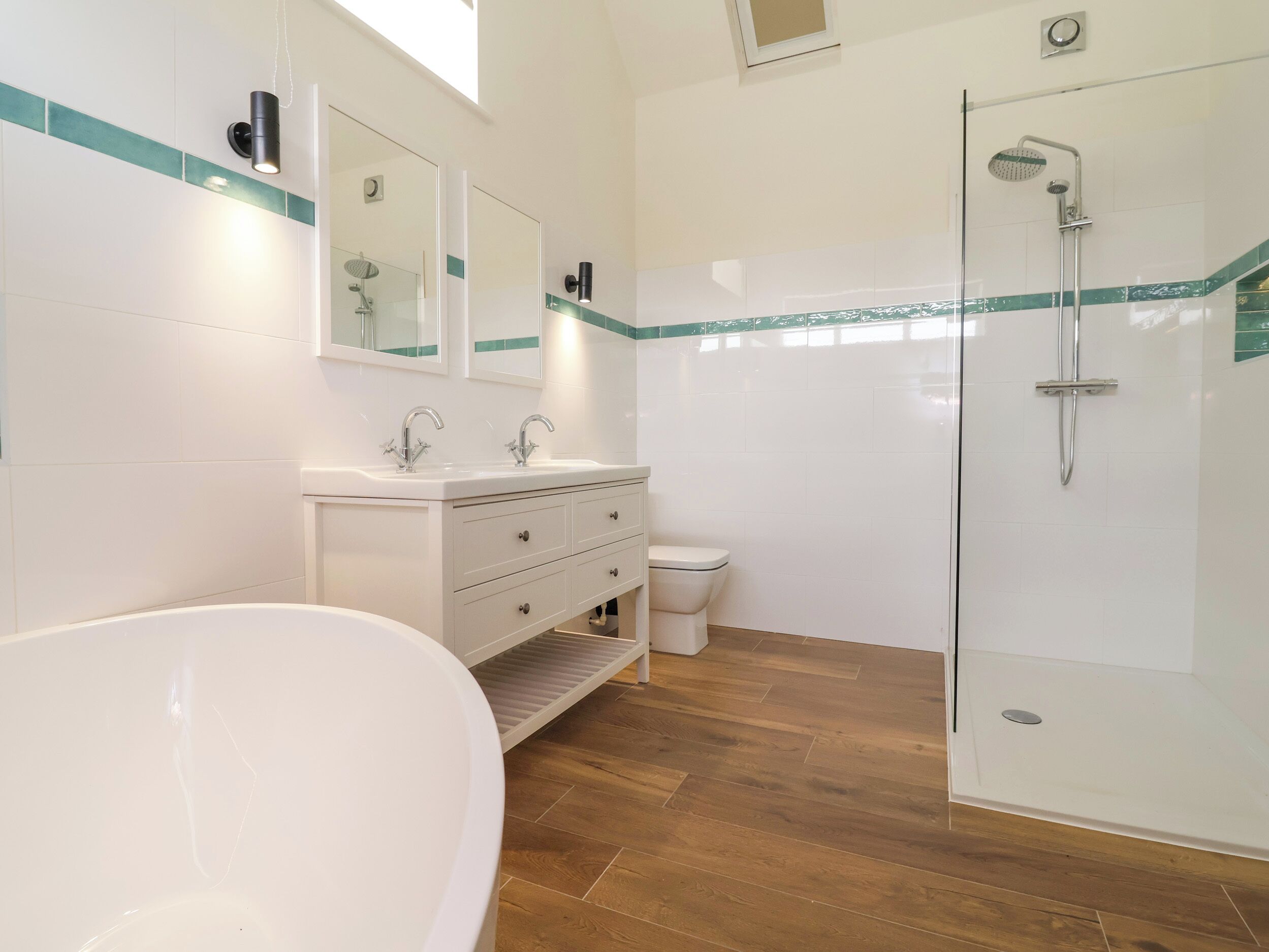A bathroom with a bathtub, a shower, a toilet, and a vanity with drawers.