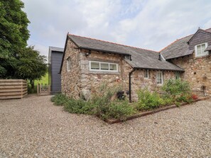 A stone house with a gravel driveway and a wooden fence. - The Barn (Mold)