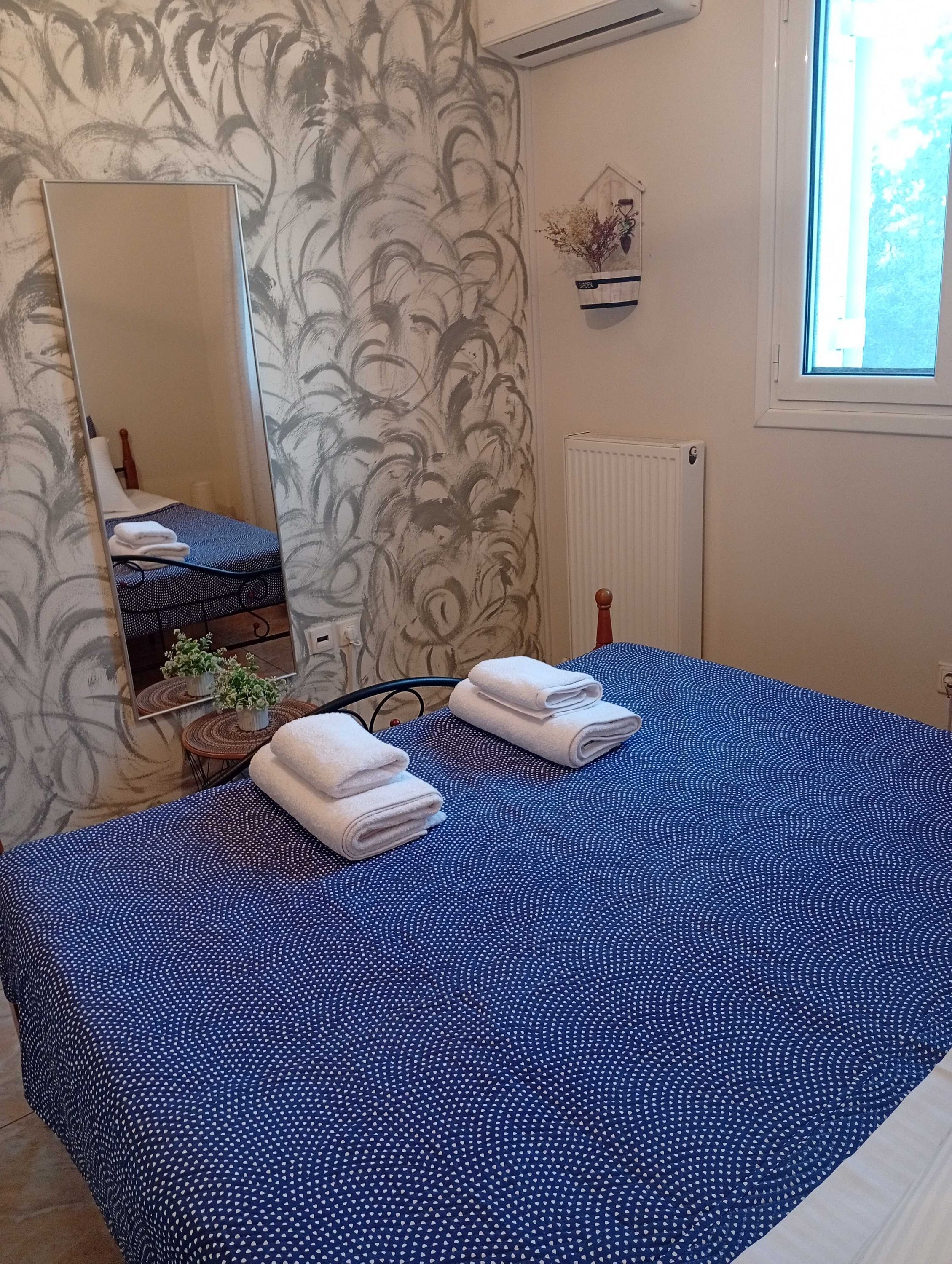 Un dormitorio con una cama grande, un espejo, un radiador y una ventana.