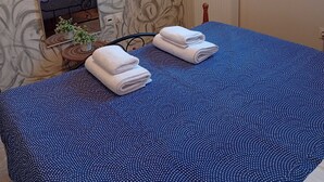 Un dormitorio con una cama grande, un espejo, un radiador y una ventana.