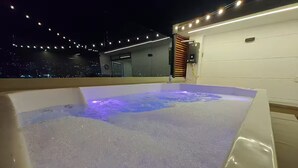 Ein Whirlpool mit Blick auf die beleuchtete Stadt.