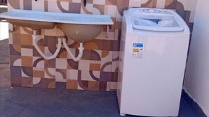 Un baño con lavamanos, lavadora y pared estampada.