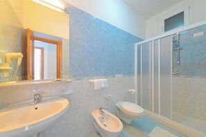 A bathroom with a sink, bidet, toilet, and shower. - Armonia (Barano D'ischia)