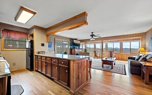 A spacious kitchen with wooden cabinets, a large island, and a dining area with a sofa and table.