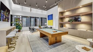 A modern indoor space with a pool table, bar area, and seating. - Luxury 1BR Downtown Miami I Free Parking + Pool (Miami)