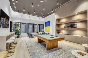 A modern indoor space with a pool table, bar area, and seating. - Luxury 1BR Downtown Miami I Free Parking + Pool (Miami)