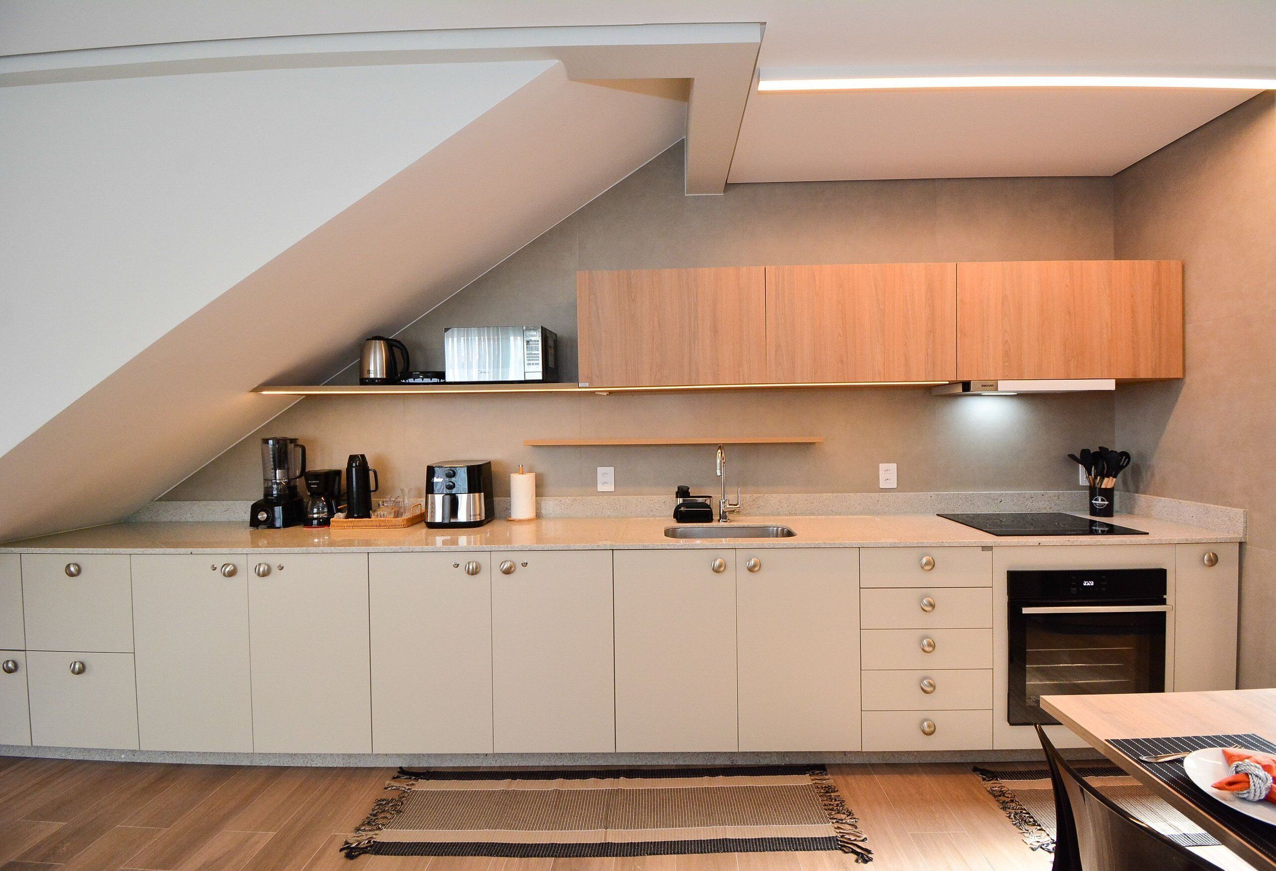 A modern kitchen with a built-in oven, a coffee maker, and a sink.