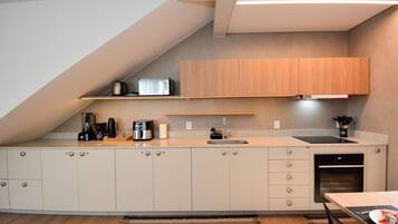 A modern kitchen with a built-in oven, a coffee maker, and a sink.