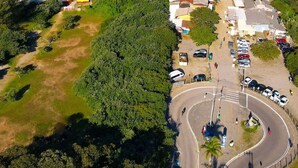 Vista aérea de una zona costera con playa, aparcamiento y edificios.