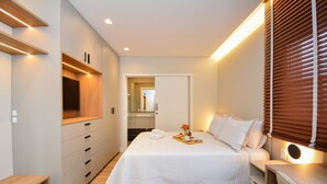 Una habitación de hotel moderna con cama, mesita de noche y armario empotrado.