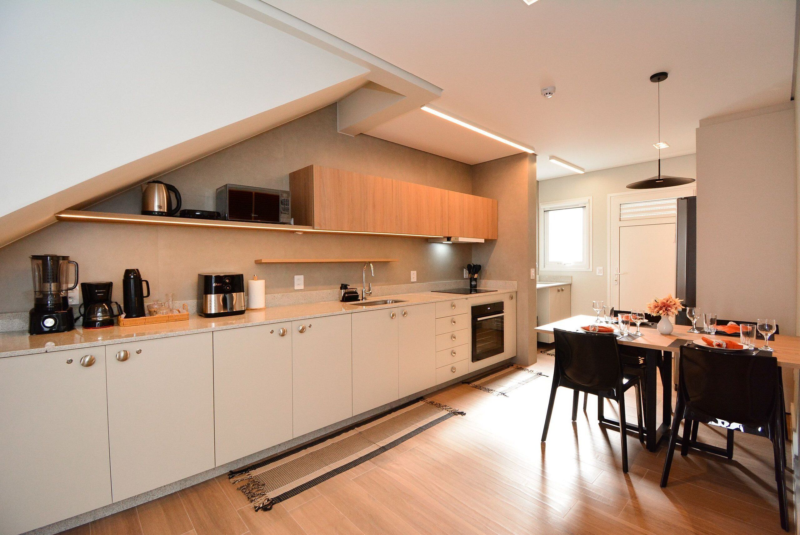 A modern kitchen with a built-in oven, a coffee maker, and a microwave.