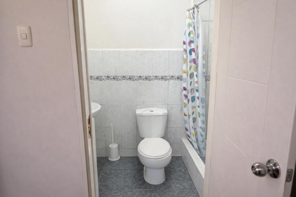 Ein Badezimmer mit Toilette, Bidet und Duschvorhang.