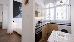 Eine moderne Küche mit Essbereich, einem Bett und einem großen Fenster.