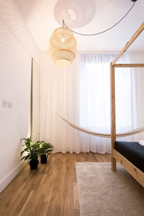 A room with a wooden bunk bed, a large mirror, a hanging light fixture, and two potted plants. - The Holborn Hideaway by The Design Traveller (London)