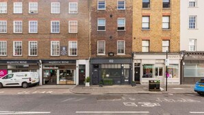 A row of brick buildings with storefronts, including a wine shop and a shop with a sign reading 'TKS SOI'. - Chic Marylebone Village  Premium Mattress   55   TV (London)