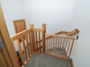 A wooden staircase with a handrail and carpeted landing. - 2 Court Cottage, Hillfield Village (Dartmouth)