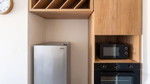 Una cocina equipada con microondas, horno y refrigerador.