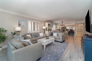 Ein geräumiges Wohnzimmer mit einer Couch, einem Couchtisch und einem Essbereich mit Stühlen.