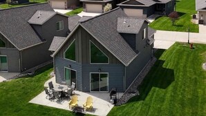 Un edificio residenziale con un'ampia zona patio, un'area salotto esterna coperta e un garage.