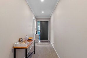 A hallway with a table, a door, and a window. - Riverstone Retreat - Turangi Holiday Home (Turangi)