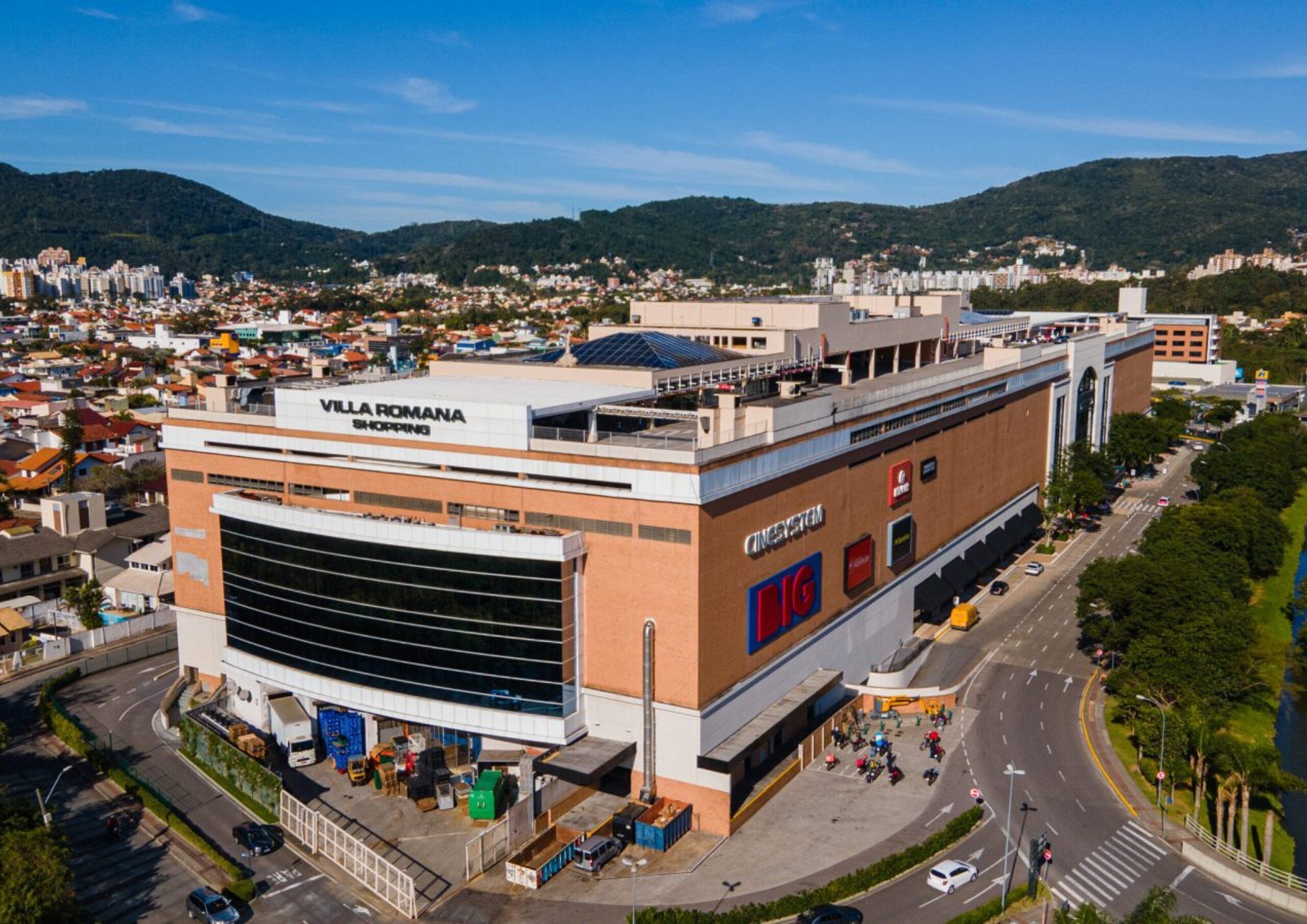 A large commercial building with a prominent sign for 'Villa Romana Shopping.'