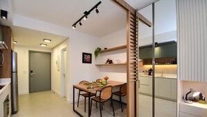 Una cocina moderna con comedor, refrigerador y pileta.