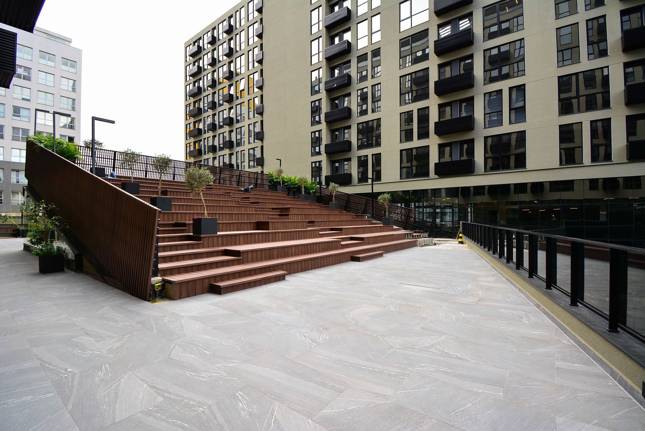 A modern building with a staircase leading to a higher floor, surrounded by other high-rise buildings.