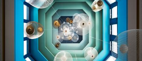 A geometric ceiling design with multiple hanging spherical light fixtures.