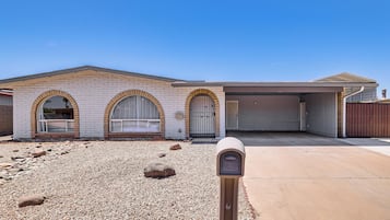 Une maison à deux étages avec un garage, une allée et une boîte aux lettres.