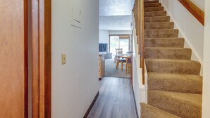 A hallway leading to a dining area with a carpeted staircase. - Unwind Poolside, Walk to Main St! Winter Park Stay (Winter Park)