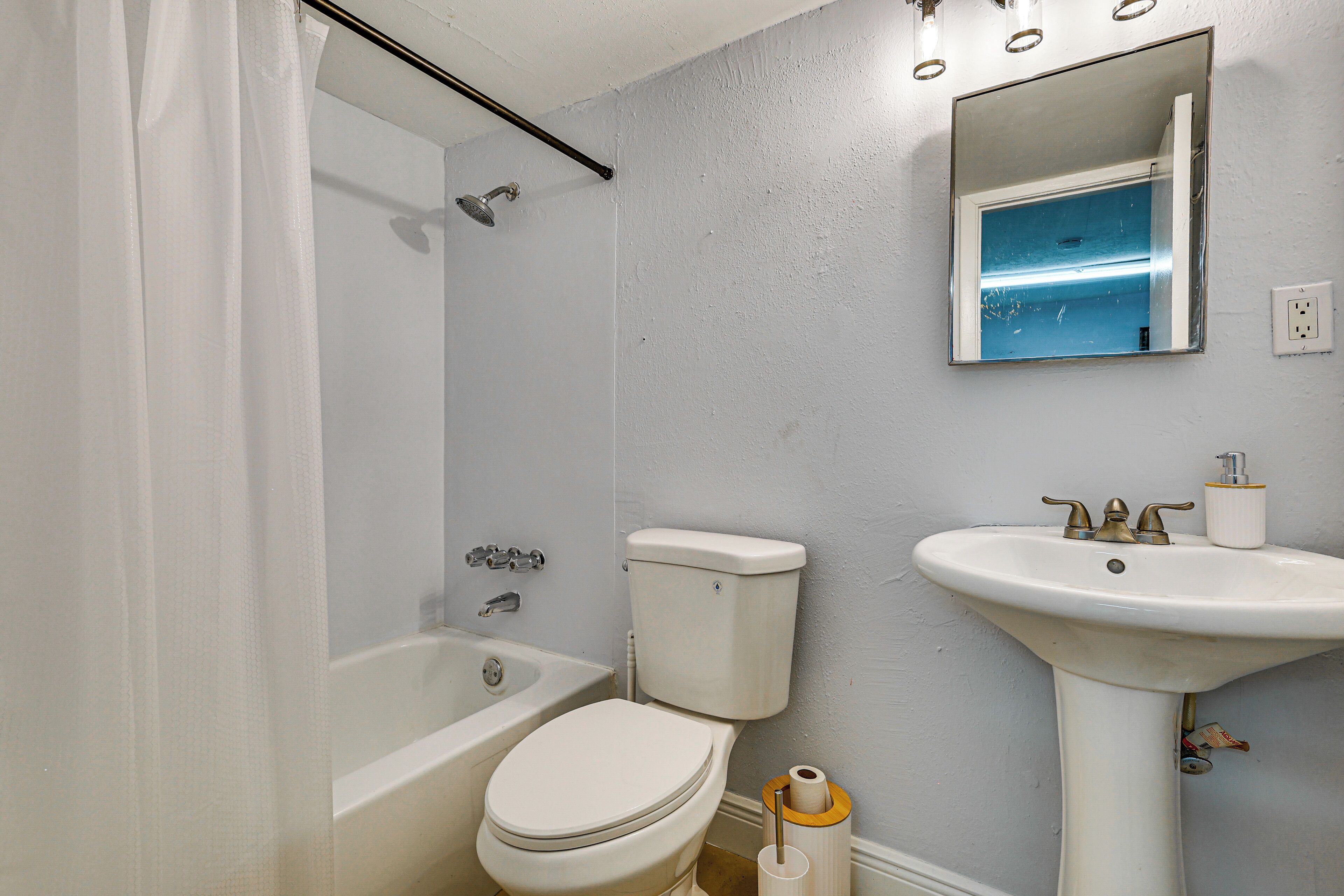 A bathroom with a bathtub, toilet, and sink.