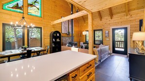 Ein Holzblock-Interieur mit Essbereich, Küche und einem großen Fenster mit Blick.