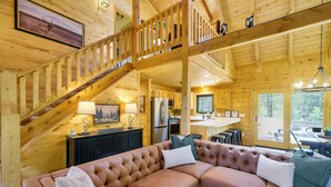 Ein Holzblock-Interieur mit Treppe, Wohnbereich mit Sofa, Küche und Essbereich.
