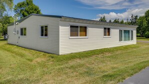 Ein Bungalow mit flachem Dach, einer Veranda und einer kleinen angebauten Garage.