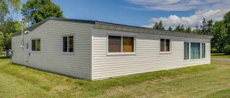 A single-story mobile home with a flat roof, a front porch, and a small attached garage.