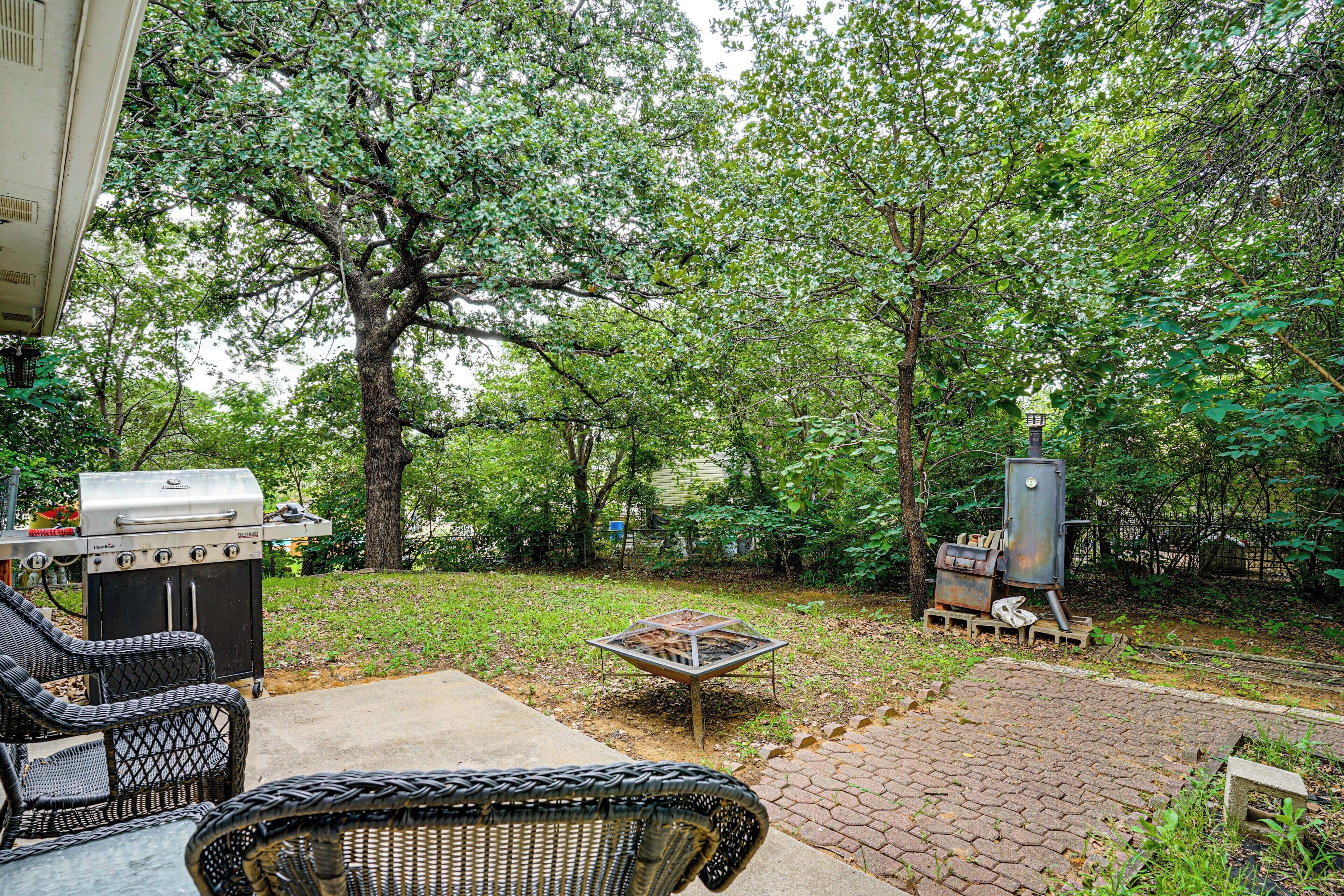 An outdoor patio with wicker furniture, a grill, and a metal table.