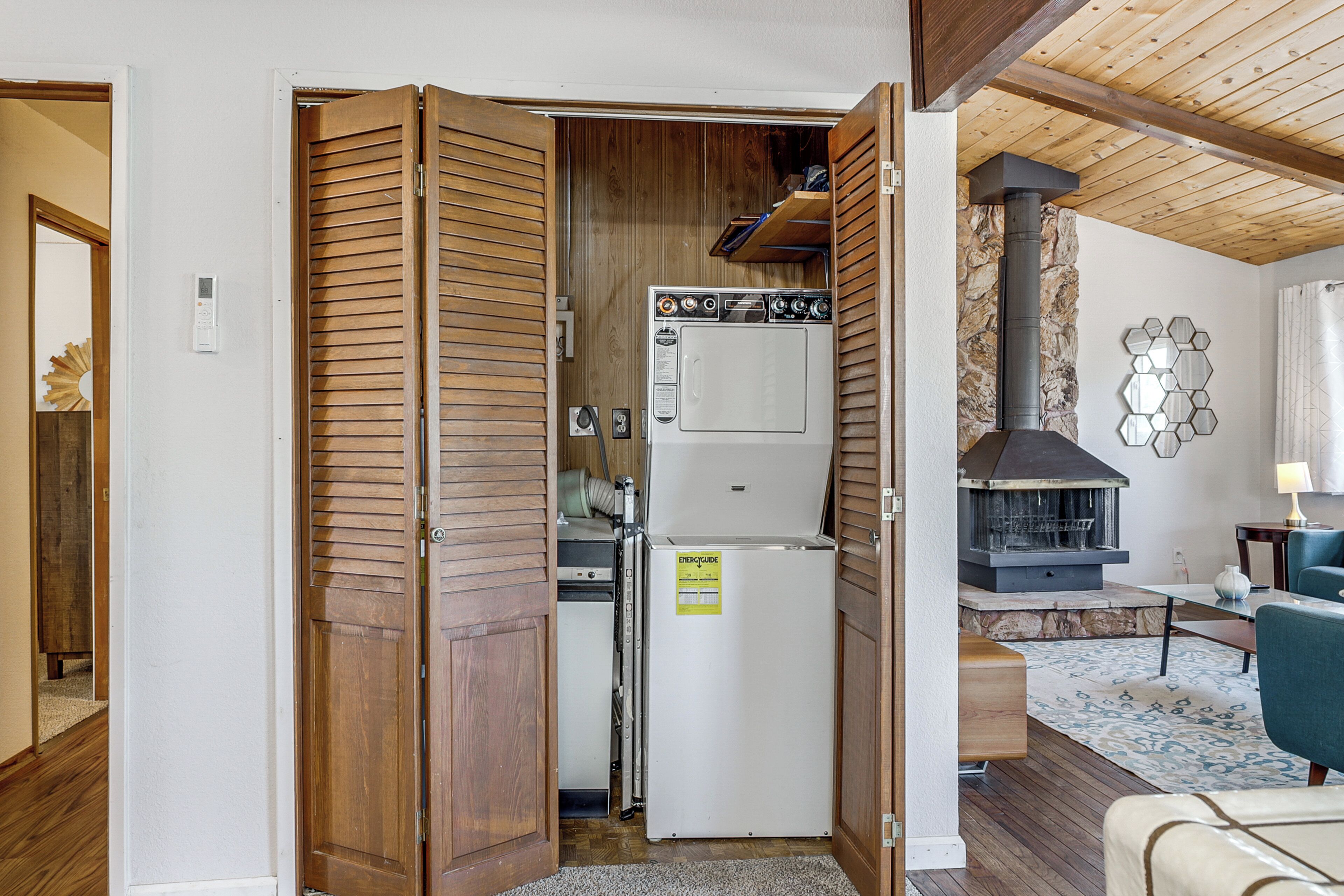 A compact living space with a kitchenette, a built-in wood stove, and a seating area.