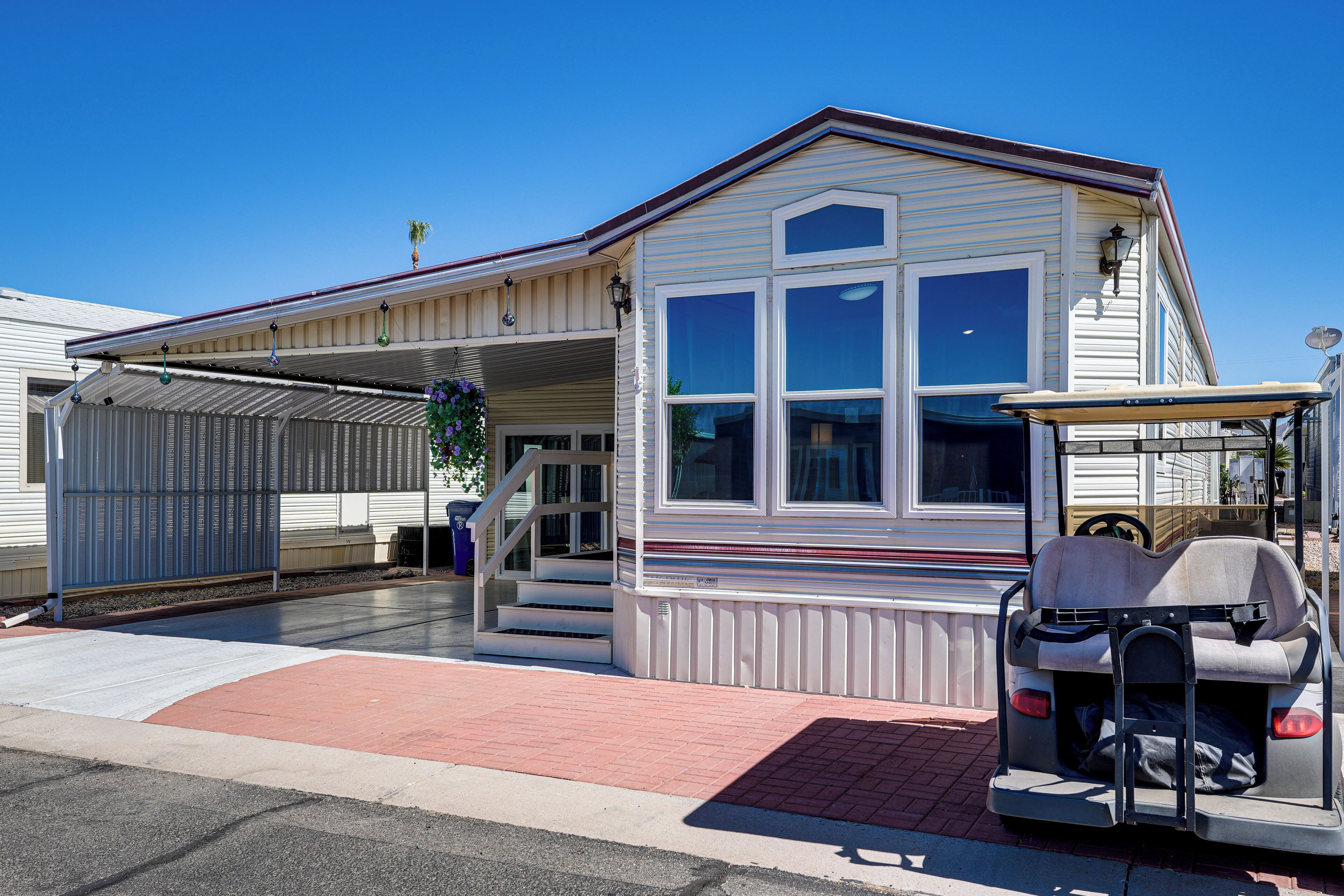 A single-story building with a covered porch, a garage, and a small attached structure with a roof.