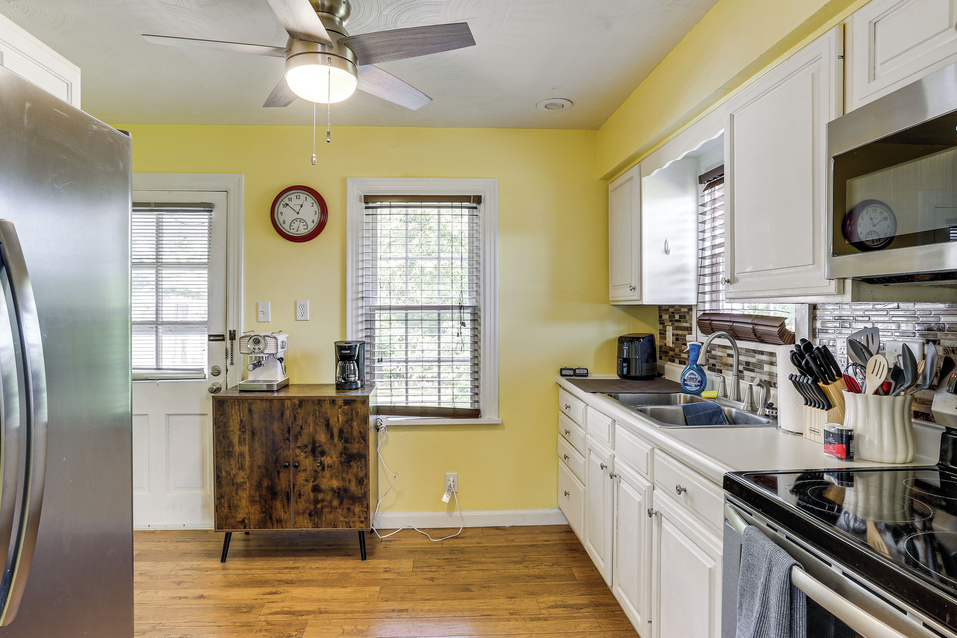 A kitchen with a refrigerator, microwave, stove, and cabinets.